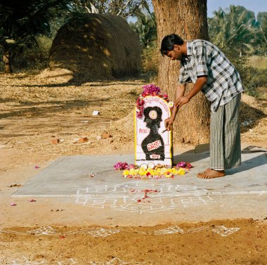 Rangoli, yer dekorasyonu ve çiçekler Mandya, Karnataka, Hindistan yakınlarındaki AIDS amma, Menasikyathanna Halli köyü olarak bilinen küçük bir türbeye sunuluyor.