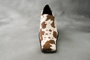 Gri arka planda yamaları olan deri deri ayakkabı.