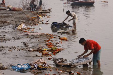 Varanasi uttar pradesh Hindistan 'da Ganga nehrinde kumaş yıkayan bir adam. 