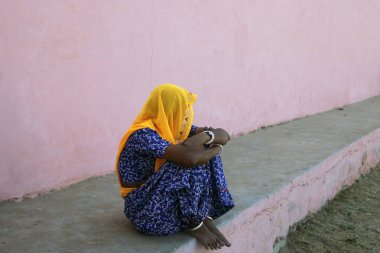 Rajasthani denen kadın sokakta tek başına oturuyor.