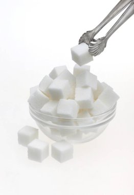 Cam kasede şeker küpleri ve maşayla