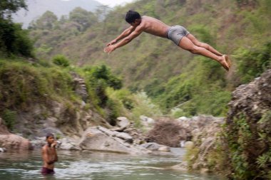 Hintli çocuk nehre atlıyor, Himalaya Foothills of Himalaya, Dehradun, Uttranchal, Hindistan