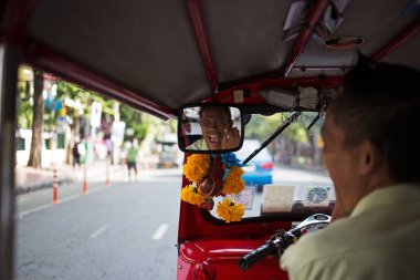 Tuk Tuk sürücüsü aynaya, Bangkok 'a, Tayland' a gülümsüyor 