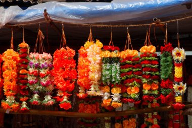 Asılı suni çiçeklerin renkli çelenkleri