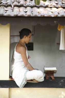 Sri Sadvidya Sanjivini Rigveda Pathshala, young students of religious studies learning by heart Vedas sitting in asana posture near Shankarchaya and Sharda temple, Kaldi, Kerala, India   clipart