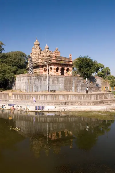 stock image Sangemeshvar, lord shankar shiva temple on bank of river karha & chamblis confluence, women washing cloth on ghat at Sasvad village, taluka Purandar, district Pune, Maharashtra, India 