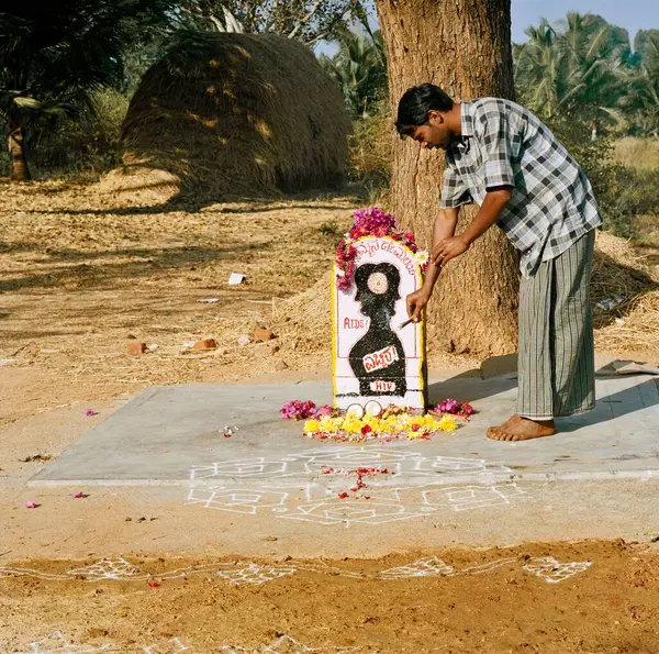 Rangoli, yer dekorasyonu ve çiçekler Mandya, Karnataka, Hindistan yakınlarındaki AIDS amma, Menasikyathanna Halli köyü olarak bilinen küçük bir türbeye sunuluyor.
