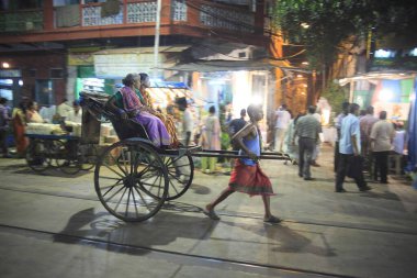 rickshaw puller transports passenger Durga Puja at Kolkatta India  clipart