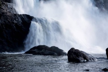 Picnic spot ; landscape Athirappilly waterfall gushing water spray ; District Thrissur ; Kerala ; India clipart