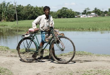 Bisikletiyle yolda yürüyen bir adam, Kuganj, Bihar, Hindistan 