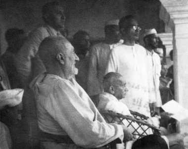 Khan Abdul Gaffar Khan; Mahatma Gandhi; Mridulabehn Sarabai terasta oturuyor ve bir sahneyi izliyor; Bihar 'daki ayaklanma bölgelerine yaptıkları ziyaret sırasında; 1947; Hindistan; 