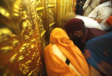 Sikh paying respects at golden doors, celebrations of 300th year of consecration of perpetual Guru Granth Sahib; Sachkhand Saheb Gurudwara in Nanded, Maharashtra, India  clipart