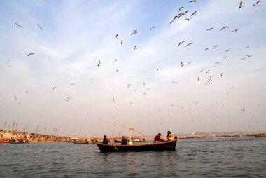Takipçiler Ganj kavşağına ulaşan teknede oturuyorlar; Ardh Kumbh Mela, Allahabad, Uttar Pradesh; Hindistan; 