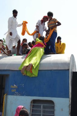 Erkekler kadını tren istasyonunda türbanla sürüklediler. Jodhpur, Rajasthan, Hindistan. 