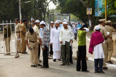 Men arriving for their Eid al Fitr or Ramzan id namaaz at Lashkar, e, Eidgaah ground after security checking, Malegaon, Maharashtra, India    clipart