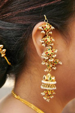 Earring worn by an Indian Gujarati lady during a Gujarati wedding , The jewelry is called ' Jadtar' in Gujarati , India clipart