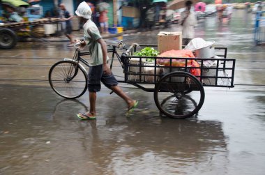 Batı Bengal Hindistan Asya 'da, Kolkata caddesinde üç tekerlekli bisiklet süren bir adam.