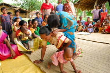 Ho kabilelerinden kadınlar sırtına biniyor ve tıbbi bilgileri paylaşıyorlar, Chakradharpur, Jharkhand, Hindistan   