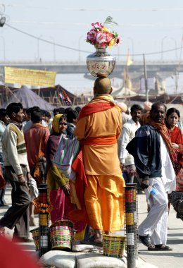 A saint, sadhu takes photographs of his fellow sadhus with a film camera during the Ardh Kumbh Mela, one of the worlds largest religious festivals at Allahabad, Uttar Pradesh, India  clipart