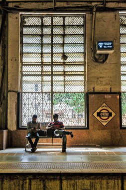 men sitting on bench, Church gate Railway Station, Mumbai, Maharashtra, India, Asia