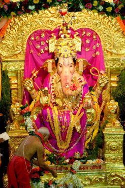 Priest performing pooja of gsb ganpati idol in ganesh festival, Bombay Mumbai, Maharashtra, India  clipart