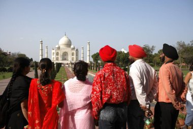 Sikh family viewing at Taj Mahal Seventh Wonders of World on the south bank of Yamuna river , Agra , Uttar Pradesh , India UNESCO World Heritage Site clipart