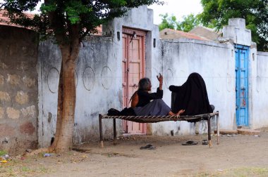 Anjaar, Kutch, Gujarat, Hindistan yakınlarındaki Mindiyada 'daki evin önünde oturan yaşlı kadınlar 