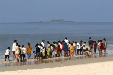 Udupi, Karnataka, Hindistan 'dan 4 kilometre uzaklıktaki Malpe Sahili' nde Arap denizinin tadını çıkaran okul çocukları ve öğretmenler. 