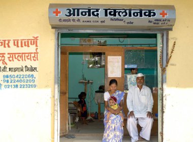 Pune, Maharashtra, Hindistan yakınlarındaki Ralegan Siddhi 'deki özel klinikteki köylüleri muayene eden doktor. 