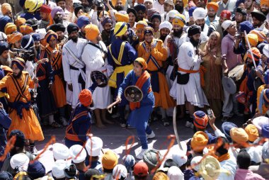 Nihang Sikh hayranları, Hola Mohalla festivali, Anandpur Sahib, Punjab, Hindistan vesilesiyle kalabalıkta dövüş sanatları icra ediyorlar.  