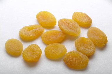 Beyaz arkaplanda yarı kurumuş kayısılar izole edilmiş. 