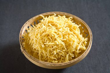 Atıştırmalıklar, gri arka planda kamış kasesinde süslü sev.  