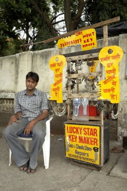 Bombay 'da, Maharashtra' da, Hindistan 'da, Hindistan' da, bir patikada mallarını kuran büyük anahtar kesiciler sergileyen yedek bir anahtarcı.