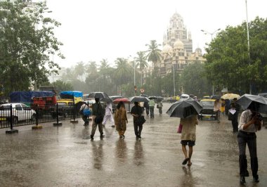 Şiddetli yağmur ve kilise istasyonu muson yağmurları, Bombay Mumbai, Maharashtra, Hindistan 'da şemsiyeli insanlar inşa ediyor.