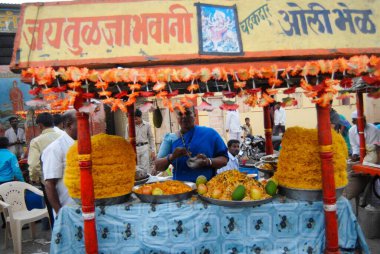 Bir kadın Poha Chivda 'ya, Hindistan' ın Maharashtra ilçesindeki Dimba köyündeki yerel bir panayırda fıstık, yer fıstığı ve baharatla tatlandırılmış çıtır çıtır bir pirinç satıyor. 