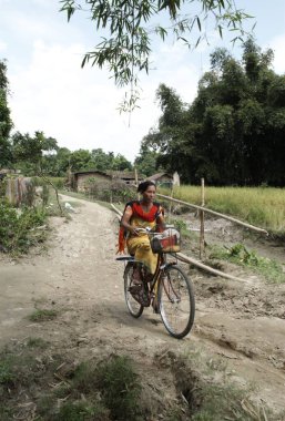 Woman riding cycle, Bongaigaon, Assam, India  clipart