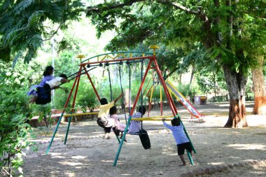 Çocuklar parkta salıncakta sallanıyor, Gujarat, Hindistan