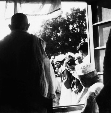 Mahatma Gandhi and Madan Mohan Malaviya looking out of a window watching a students procession at Benares Hindu University ; Varanasi ; 1941 ; India  clipart