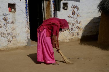 Yerleri süpüren kadın, Khuri köyü, Jaisalmer, Rajasthan, Hindistan, Asya 