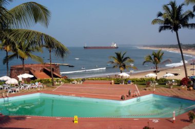 A view of swimming pool of the Taj Fort Aguada hotel near the Sinquerim beach in Goa, India  clipart