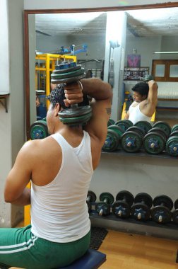 Spor salonunda egzersiz yapan Hintli adam.