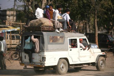 Jharkhand, Hindistan 'da yerel ulaşım sistemi olarak kullanılan jipin üstünde oturan yolcular 