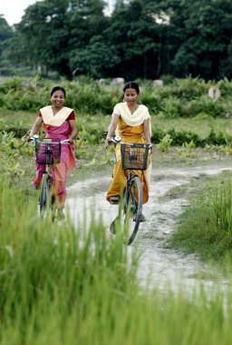 Kadınlar bisiklete biniyor, Bongaigaon, Assam, Hindistan 