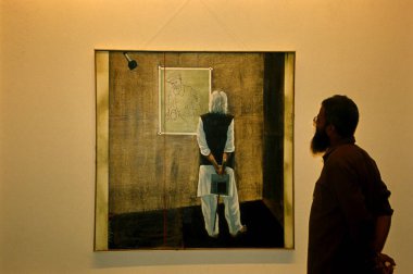 Jehangir sanat galerisinde Mumbai Bombay 'da, Maharashtra' da, Hindistan 'da bir tabloya hayran olan bir ziyaretçi.