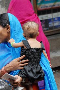 Müslüman kadınlar, Baiganwadi, Govandi, Bombay, Mumbai, Maharashtra, Hindistan 'da çocuklarıyla birlikte çocuk felci kampanyasında sırada bekliyorlar.    