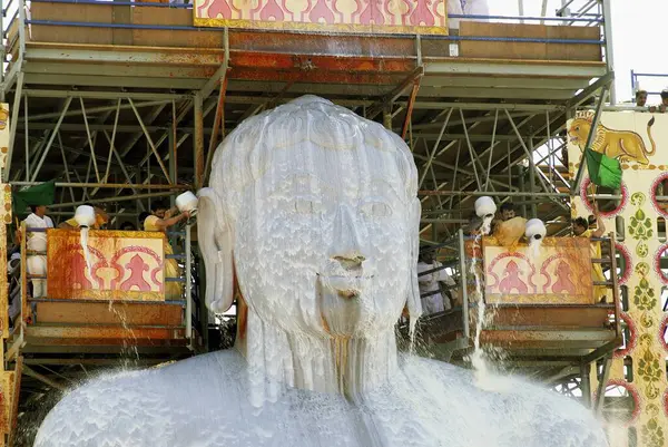 stock image Jain Devotees pouring milk on the head of 58.8 feet monolithic Statue of jain saint Gomateshwara (Lord Bahubali) in Mahamastakabhisheka (head anointing ceremony) on the Vindhyagiri hill, Shravanbelagola, Karnataka, India 