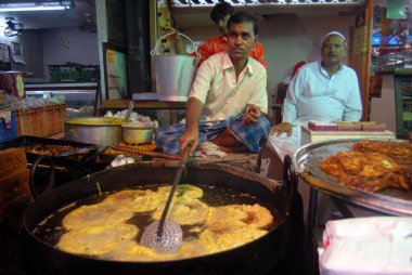 Bir gıda tedarikçisi, Müslümanlar Pydhonie, Bombay 'daki Khatri Mescidi' nde ramazan orucunu kırarken yenilebilir yiyecekler hazırlıyor. Mumbai, Maharashtra, Hindistan 
