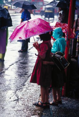 Yağmurlu bir günde şemsiye tutan çocuklar Bombay Mumbai, Maharashtra, Hindistan