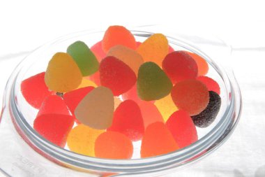 Şeffaf tepside sert diş etleri, şeker kaplı renkli yumuşak jöle tatlılar.