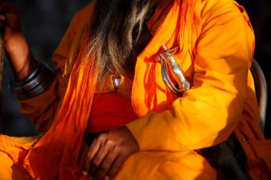 Nihang or Sikh warrior dressed up in orange robes with sword during celebrations of Hola Mohalla at Anandpur sahib in Rupnagar district, Punjab, India  clipart